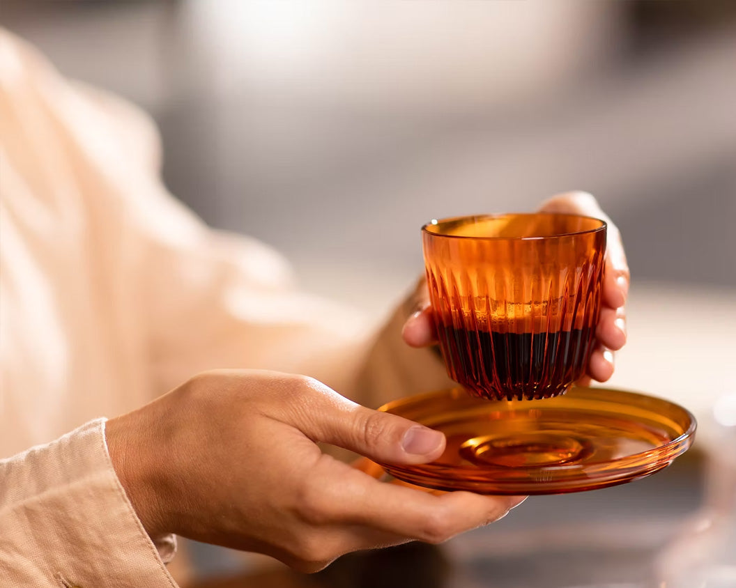 Person holding HuskeeRenew espresso cup and saucer