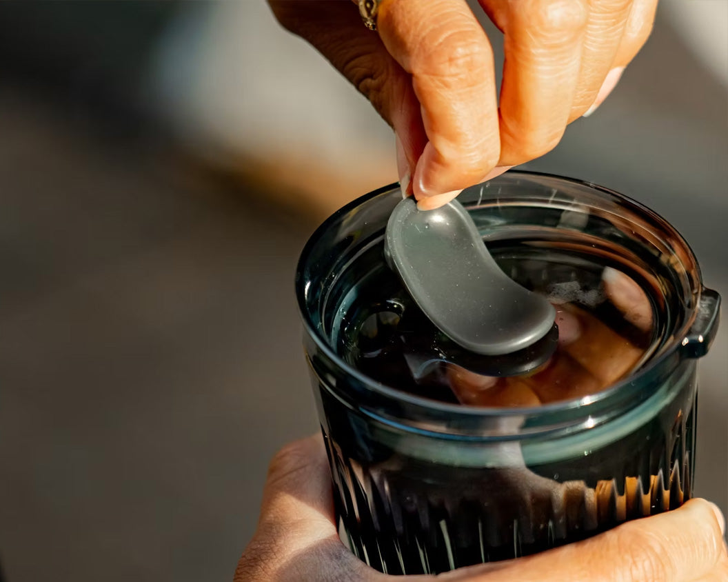Person opening the Huskee Stopper Lid on a Smoke HuskeeRenew cup